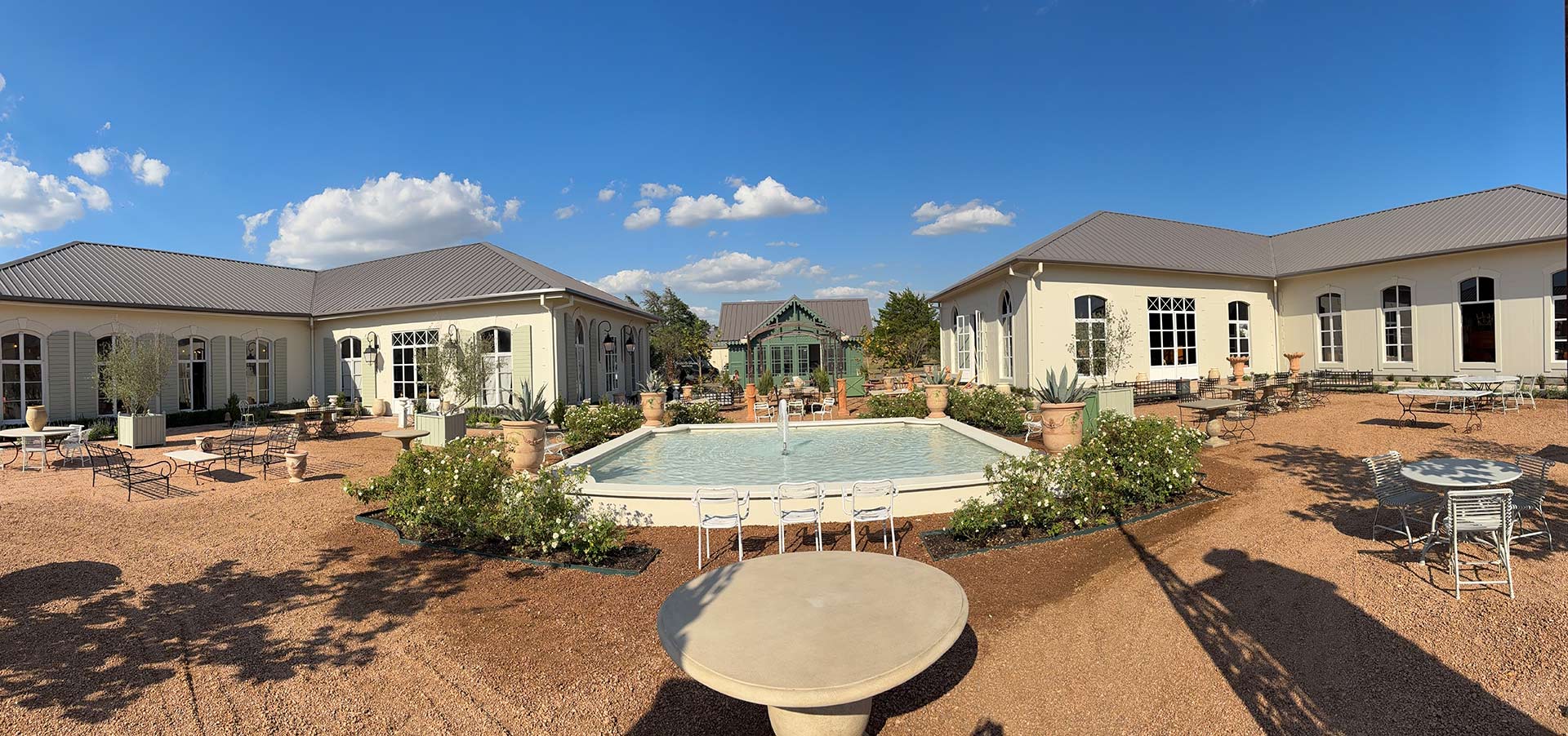 Panoramic view of Jardin de France at 108 Compound Ln with La Petite Dame Wine Bar in the center